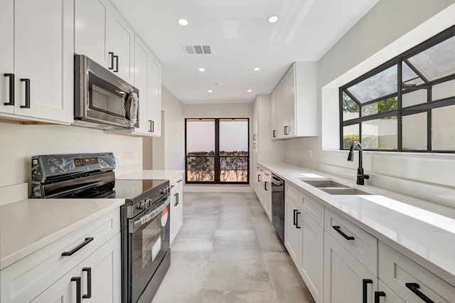 kitchen with visible vents, a sink, recessed lighting, stainless steel appliances, and white cabinets