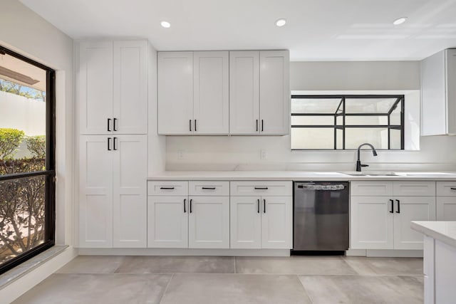 kitchen with white cabinets, dishwasher, light countertops, and a sink