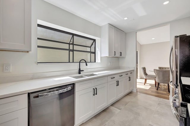 kitchen with a sink, stainless steel appliances, recessed lighting, and white cabinetry