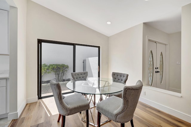 dining room with lofted ceiling, light wood-style flooring, recessed lighting, and baseboards