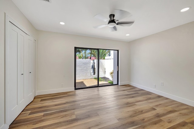 unfurnished bedroom with access to exterior, light wood-style flooring, recessed lighting, and baseboards