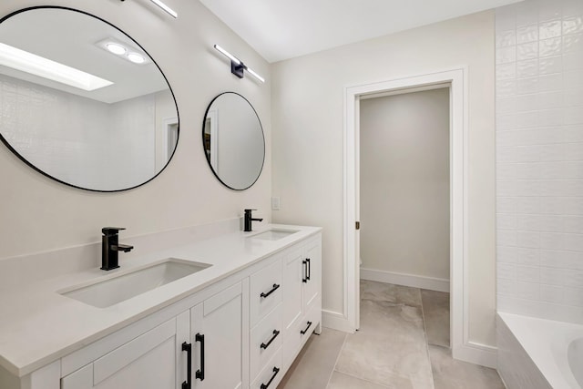 full bathroom featuring double vanity, a bathtub, baseboards, and a sink