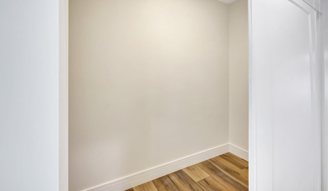 spare room with baseboards and light wood finished floors