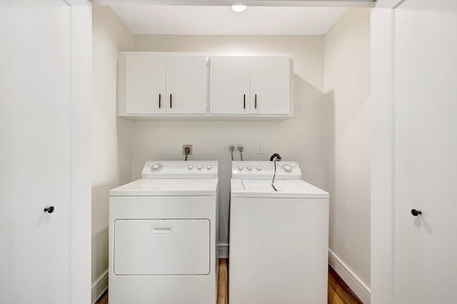 laundry room featuring cabinet space, baseboards, and separate washer and dryer