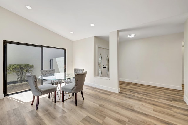 dining space featuring recessed lighting, light wood-style flooring, baseboards, and vaulted ceiling