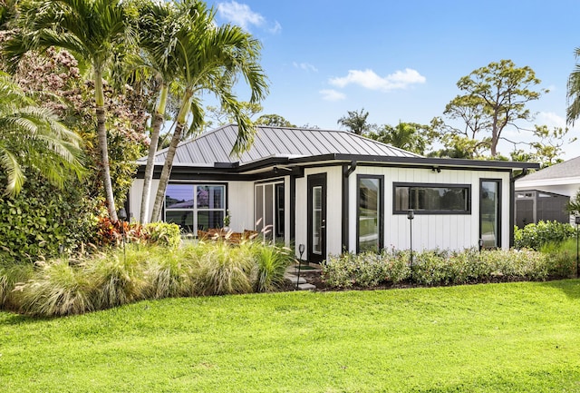 view of front facade with metal roof, a front lawn, and a standing seam roof