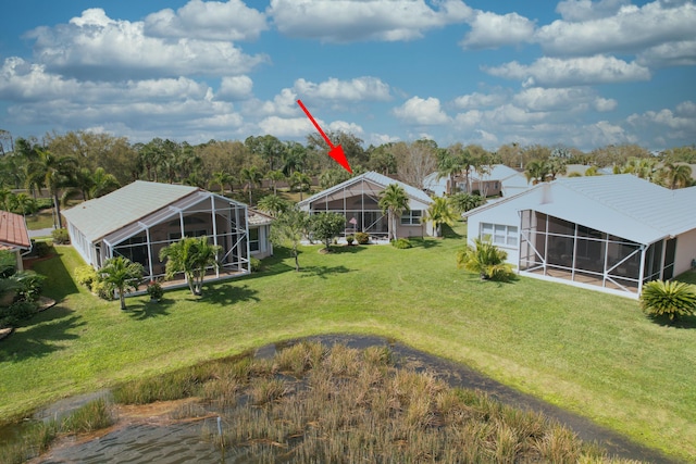 view of yard featuring glass enclosure and driveway