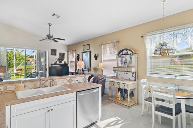 kitchen with a sink, white cabinets, open floor plan, and stainless steel dishwasher