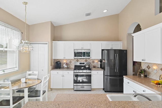 kitchen with appliances with stainless steel finishes, white cabinets, a sink, and light countertops