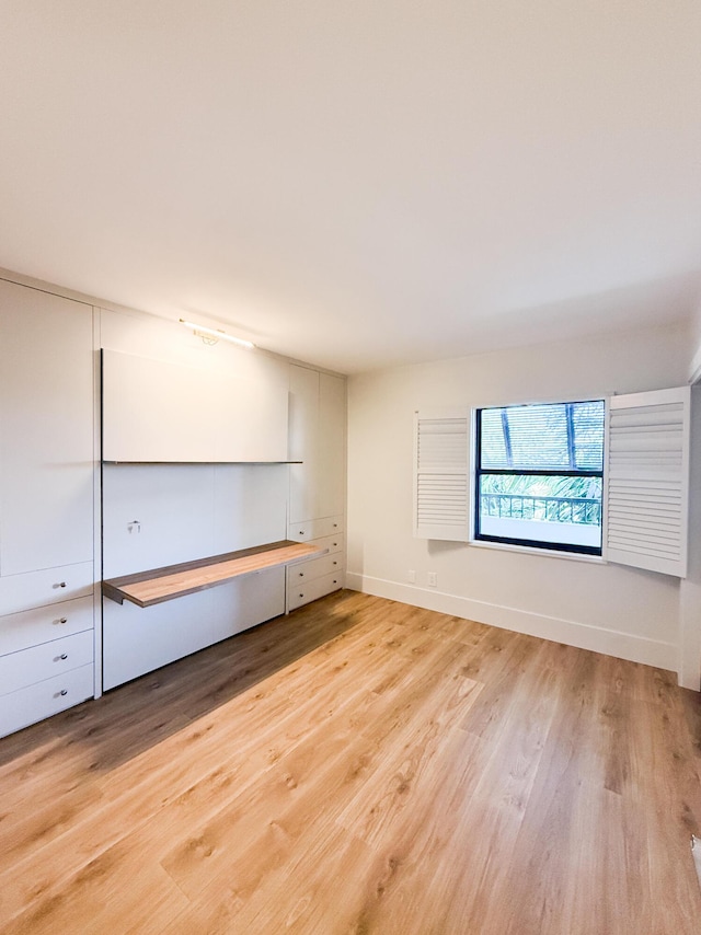 unfurnished room with baseboards and light wood-type flooring