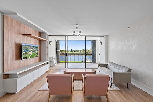 living room featuring a wall of windows, an inviting chandelier, and light wood-style floors