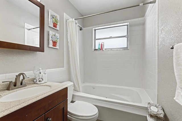 bathroom with toilet, a textured wall, shower / bath combo, and vanity