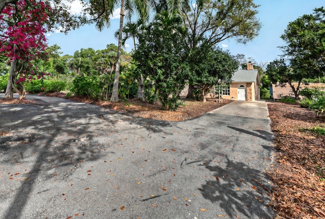 view of front of home with driveway and a chimney