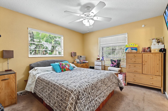 bedroom featuring a textured ceiling, multiple windows, and carpet flooring