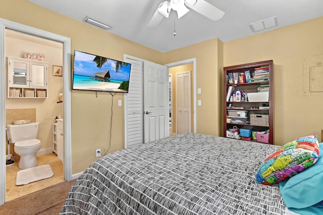 bedroom with ceiling fan, ensuite bath, visible vents, and tile patterned floors