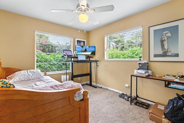 carpeted bedroom featuring ceiling fan, a textured ceiling, and baseboards