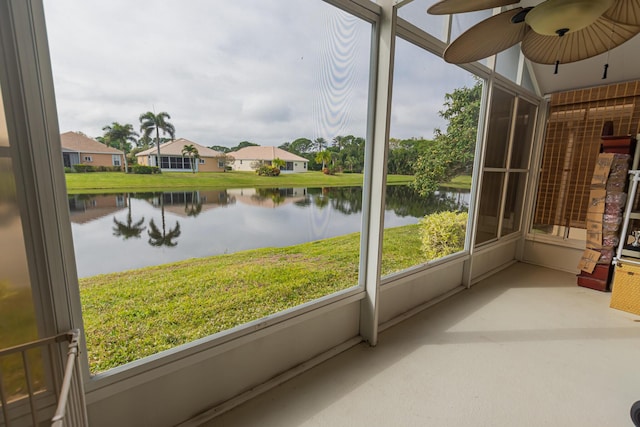 unfurnished sunroom with a water view and ceiling fan