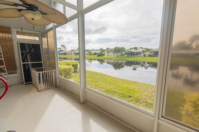 sunroom featuring a ceiling fan and a water view