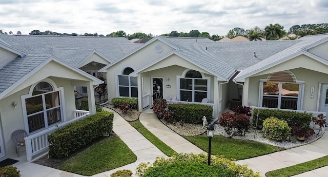 view of front of property featuring a shingled roof and stucco siding