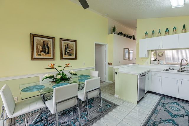 kitchen featuring light countertops, white cabinets, a sink, and stainless steel dishwasher