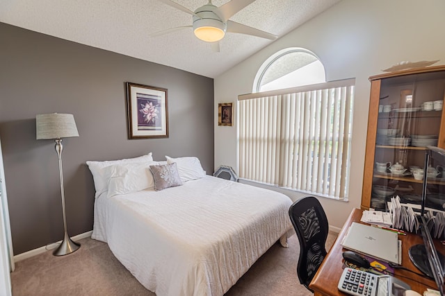 carpeted bedroom with vaulted ceiling, ceiling fan, a textured ceiling, and baseboards