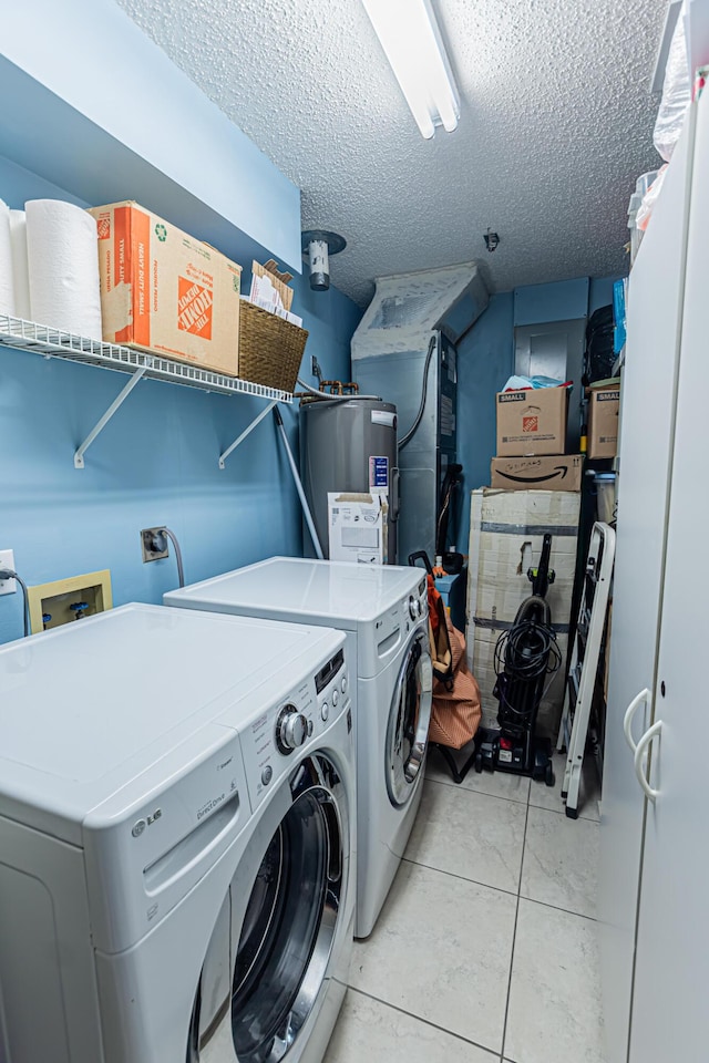 laundry area featuring light tile patterned floors, a textured ceiling, laundry area, water heater, and washing machine and clothes dryer