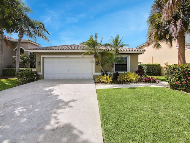 view of front of house featuring a garage, a tile roof, concrete driveway, stucco siding, and a front yard