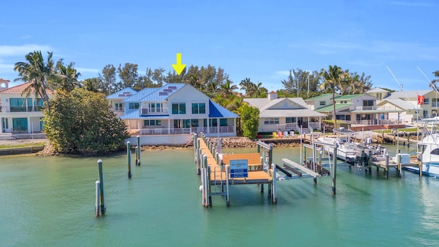 dock area with a water view, boat lift, and a residential view