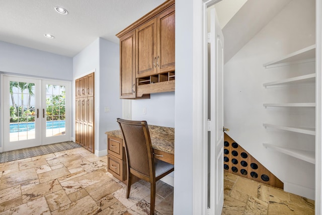 interior space with recessed lighting, stone tile flooring, a textured ceiling, and french doors