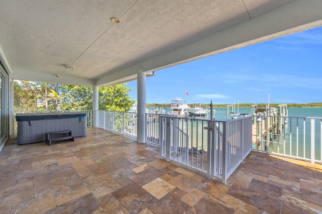 view of patio / terrace with a water view and a hot tub