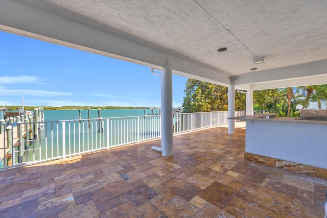 view of patio featuring grilling area and a water view