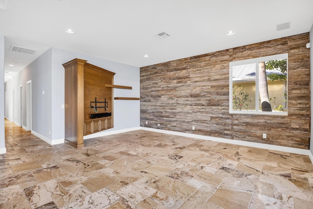 empty room with an accent wall, recessed lighting, and visible vents