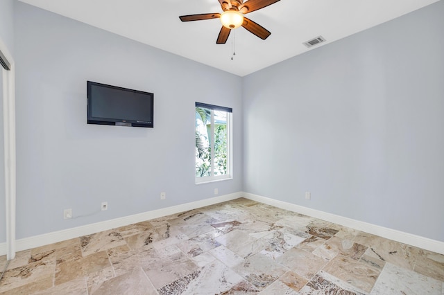 unfurnished room with a ceiling fan, visible vents, and baseboards