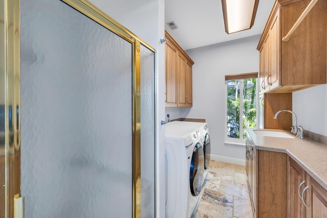 washroom with stone tile floors, cabinet space, visible vents, a sink, and independent washer and dryer