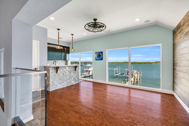 unfurnished living room featuring lofted ceiling, recessed lighting, wood finished floors, visible vents, and baseboards