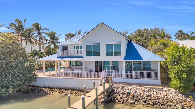 back of house with a fenced in pool, a patio, a balcony, metal roof, and a standing seam roof