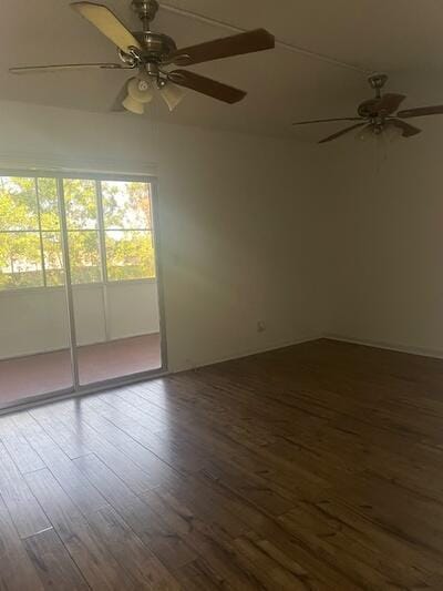 spare room with a ceiling fan and dark wood-style floors