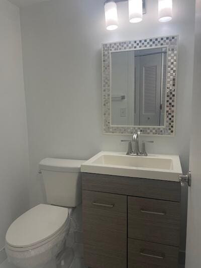 half bathroom with vanity and toilet