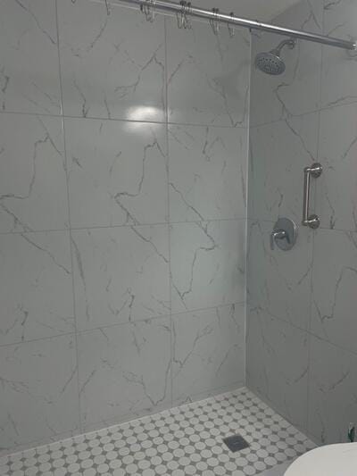 bathroom with a shower stall and toilet