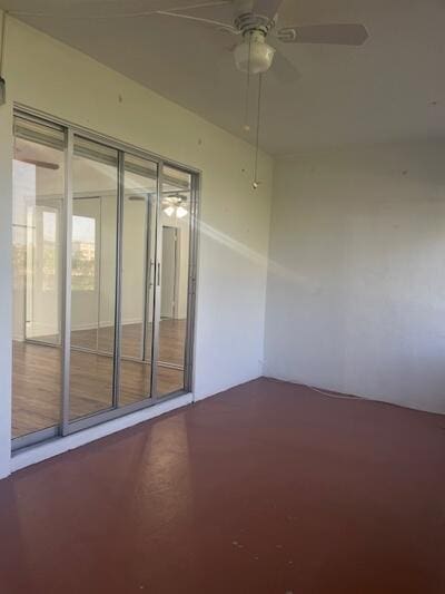 spare room with a ceiling fan and concrete flooring