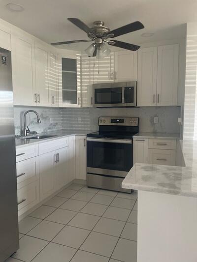 kitchen with a sink, stainless steel appliances, white cabinets, and decorative backsplash