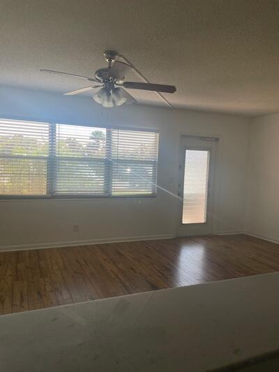 empty room with plenty of natural light, a textured ceiling, and wood finished floors