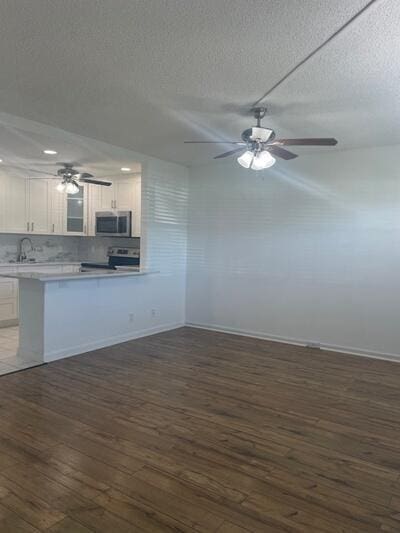 kitchen featuring a sink, white cabinets, stainless steel appliances, and dark wood-style flooring