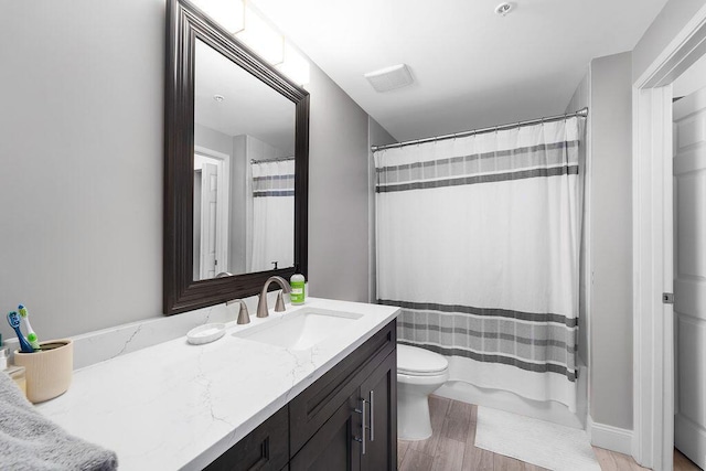 bathroom featuring toilet, curtained shower, and vanity