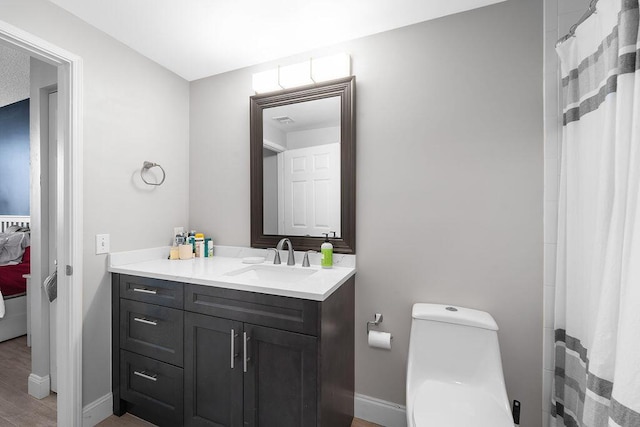 full bathroom featuring toilet, visible vents, vanity, and baseboards