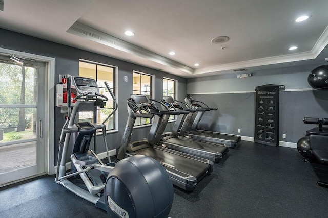 exercise room featuring crown molding, a tray ceiling, recessed lighting, and baseboards