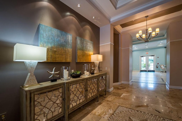 hallway with a tray ceiling, french doors, a notable chandelier, ornamental molding, and baseboards