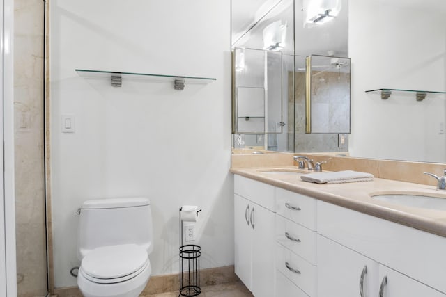 full bath with toilet, a shower stall, double vanity, and a sink