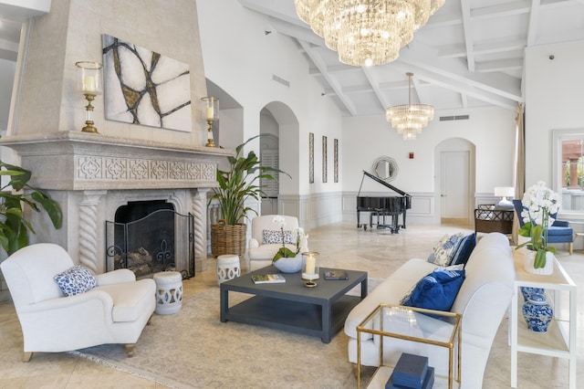 living room featuring a chandelier, arched walkways, a decorative wall, a fireplace, and visible vents