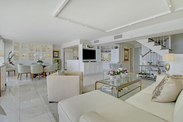 living area with marble finish floor, visible vents, and stairs